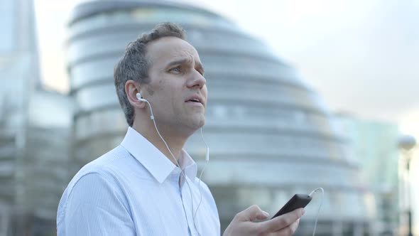 Business man makes a call in the city, in front London City Hall