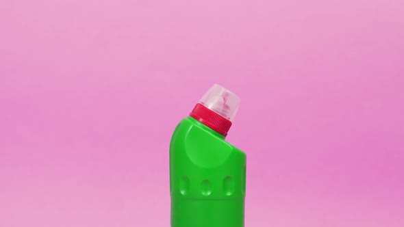 A Green Plastic Bottle with a Chemical Agent and Two Sponges for Washing Dishes