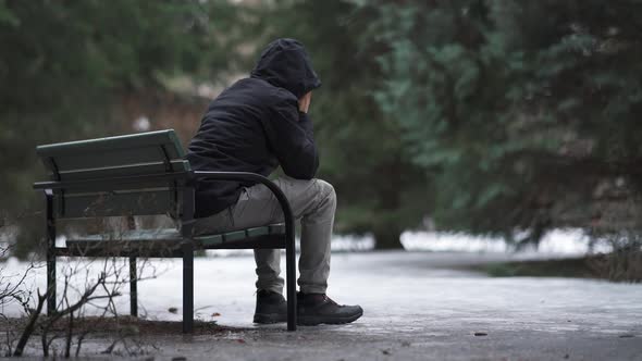 Man sitting on a bench and feeling lonely and depressed