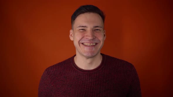 Portrait of Young Man Shouting and Smiling on Orange Background