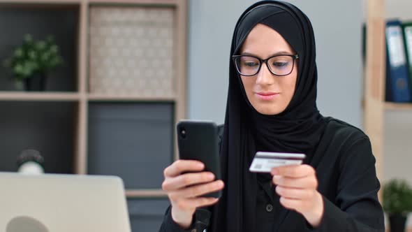 Happy Muslim Woman in Black Hijab Online Shopping Digital Card Payment Smartphone Application