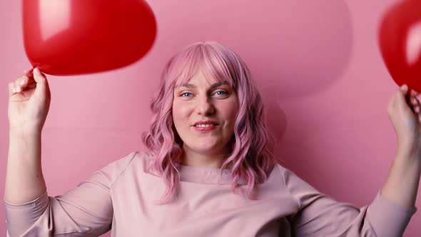 Happy Beautiful Woman in Good Mood Smiling Holding Red Balloon Shaped Heart Celebrates Birthday