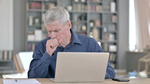 Sick Man Coughing While Working on Laptop in Office
