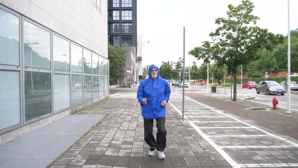 Slow motion shot of senior athletic man jogging in city