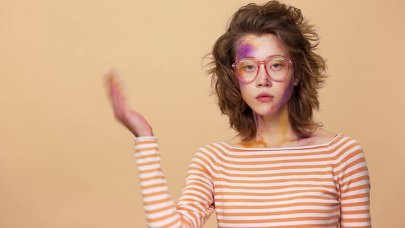 Portrait of Young Woman with Artwork on Face Touching Glasses and Seriously Demonstrating Copy Space