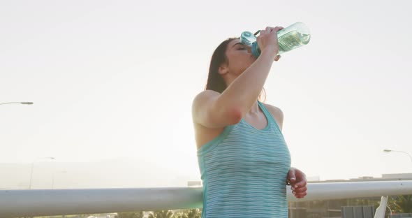 Young runner drinking water after running