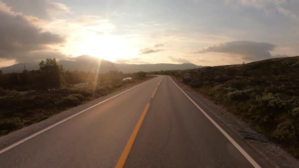 Driving a Car on a Road in Norway at Dawn