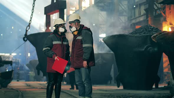 Coworkers in Safety Wear are Talking in the Metallurgical Plant Unit