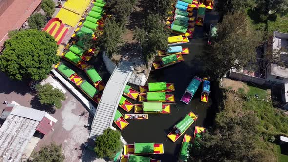 Aerial Drone Shot of colourful boats passing through Xochimilco Water Canal. Tours through water can