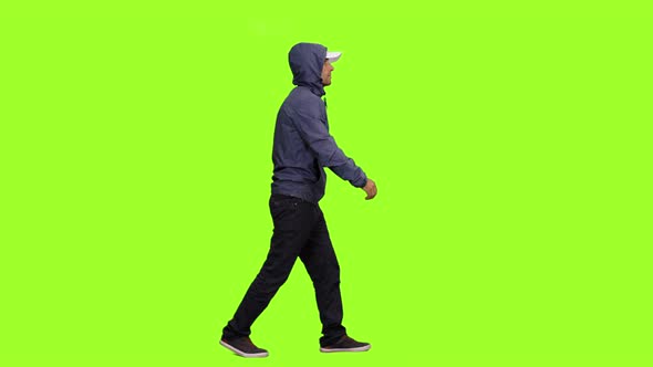 A Hooded Man Walks on Chroma Key Background