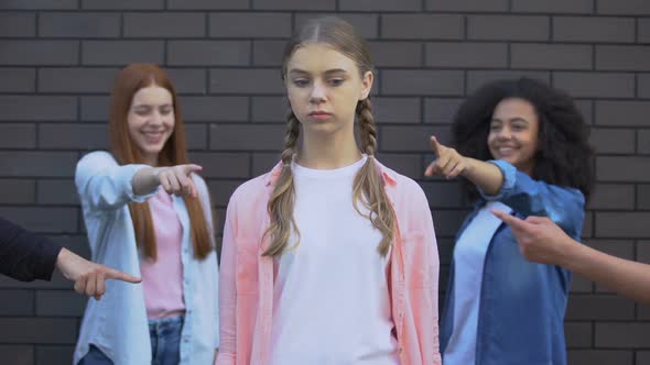 Ashamed Teenager Looking Classmates Pointing Fingers, Feeling Rejected, Conflict