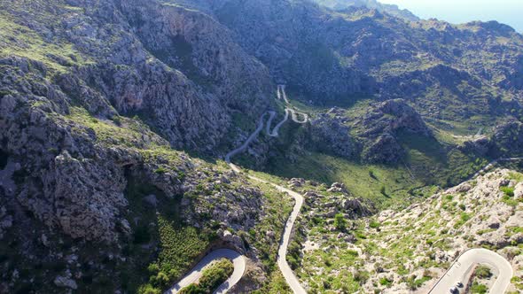 Flying above Tramontana mountains with serpentine road in the valley.