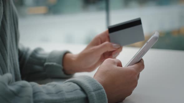 Closeup of Female Hands Holding Mobile Phone and Bank Card Shopping Online