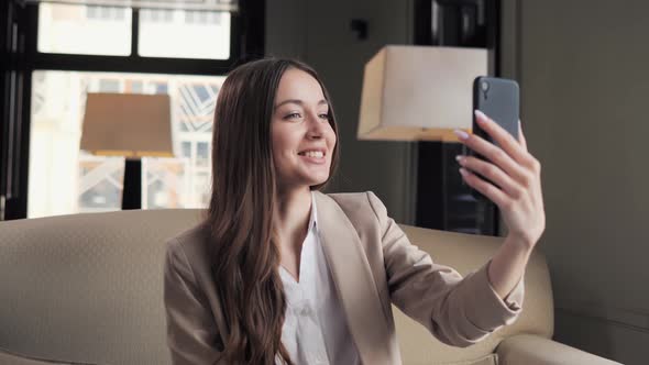 Beautiful Happy Business Woman Using Smartphone for Video Online Call in Cafe