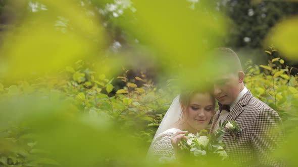 Newlyweds. Caucasian Groom with Bride Walking, Embracing, Hugs in Park. Wedding Couple