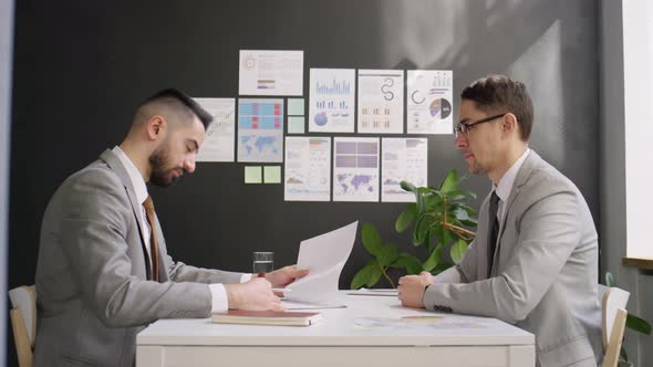 Business Partners Signing Contract and Shaking Hands