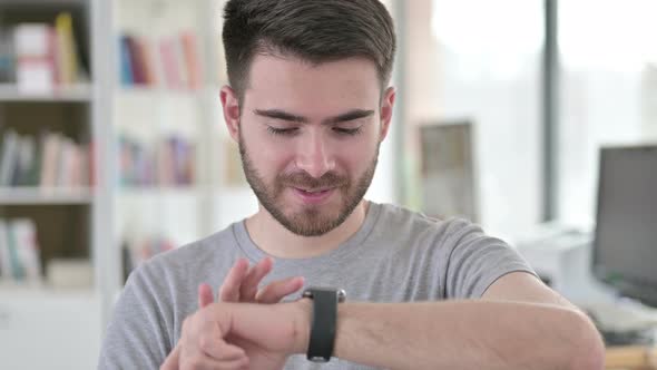 Portrait of Serious Young Man Using Smart Watch 