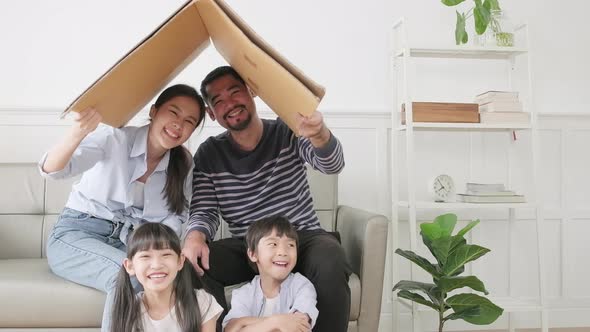 Asian family played in living room and built cardboard house with imagination.