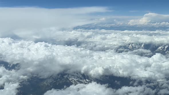 Aerial cockpit view, pilot pov, from a jet cockpit, of the italian Alps mountains, covered with some
