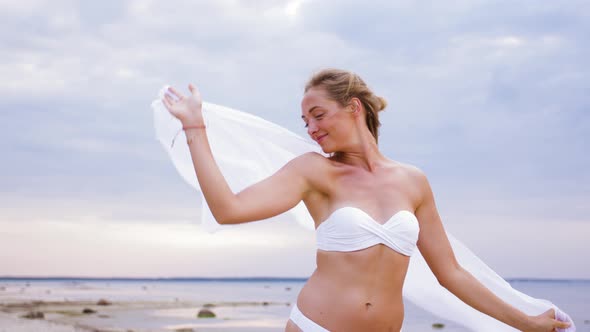 Happy Woman with Shawl Waving in Wind on Beach 