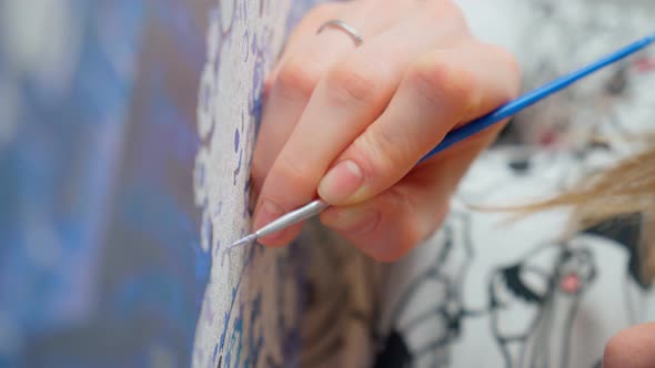 Woman Hand Holds a Brush and Paints with Paint Painting on an Easel Draws the Details of the Picture