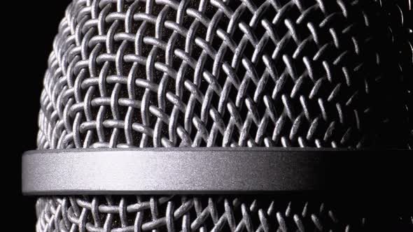 The Microphone Rotates on a Black Background. Dynamic Microphone Grid Spins Close-up alt