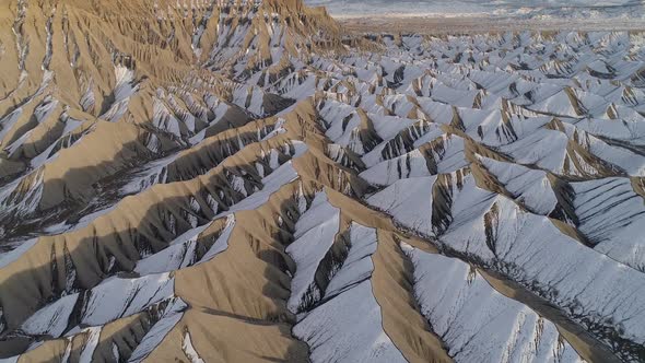 Flying backwards of dunes with snow in the Utah desert