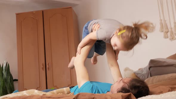 Dad and Daughter Play in Bedroom Happy Family on Bed