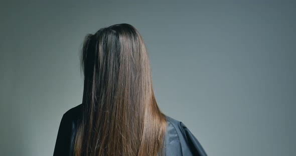 Back View of Brunette Woman Playing with Her Hair Over Clear Background