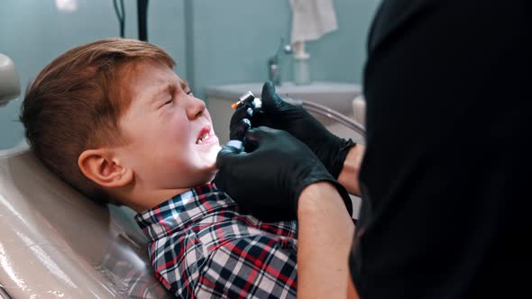 A Little Stressful Boy Getting His Teeth Done in the Dentistry