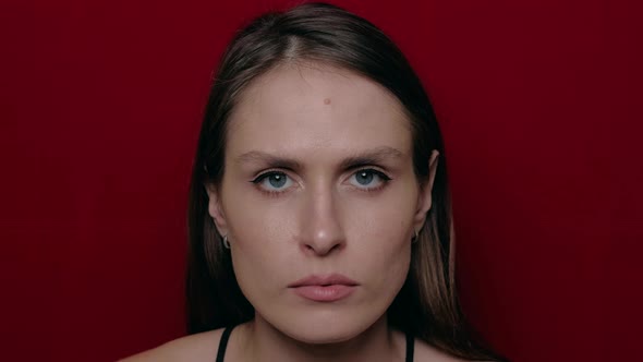 Young Brunette with a Look of Hope Isolated on Red Wall