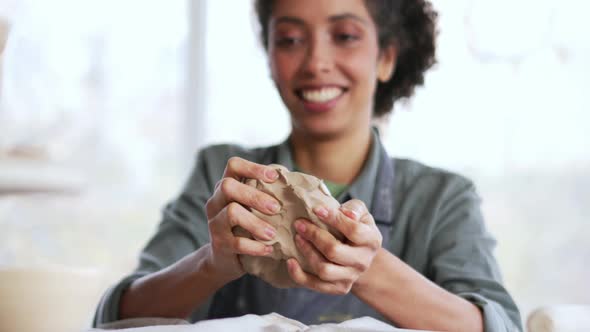 Cheerful woman potter knead clay