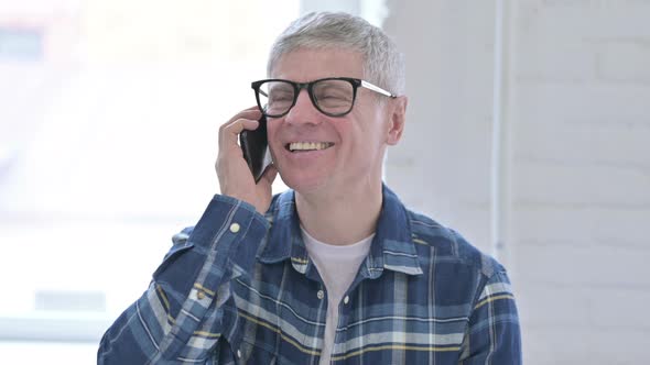 Portrait of Casual Middle Aged Man Talking on Smartphone