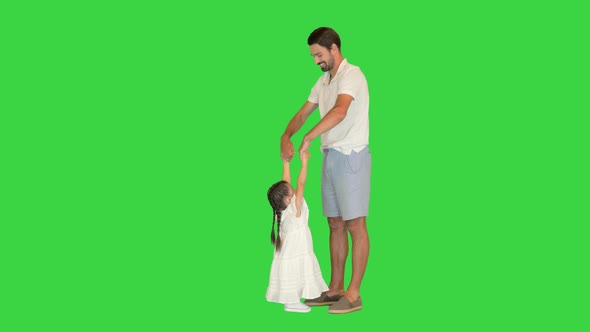 Happy Dad Is Lifting Up His Little Daughter on a Green Screen Chroma Key