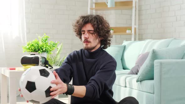 Man Playing with Soccer Ball in Front of the Camera on Bright Room Background