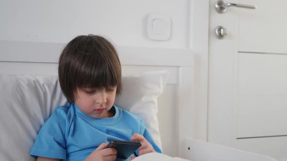 Boy Child Bed Plays Phone Blanket Suffers