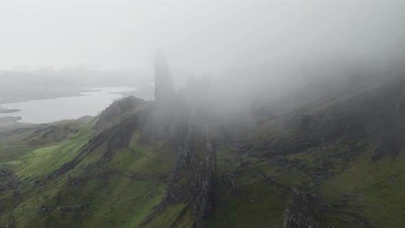 Parallax drone shot of old man of storr landscape in scotland during cloudy and foggy day. Scotland