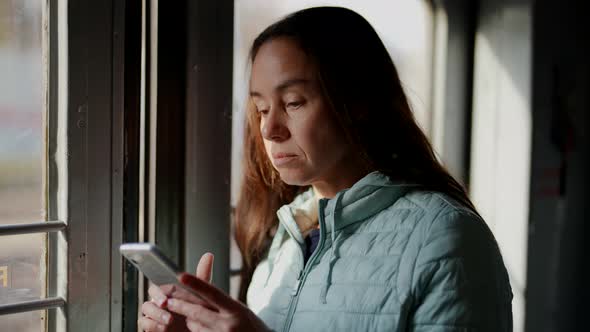 City Dweller Woman is Using Suburban Train for Travelling to Work Using Smartphone