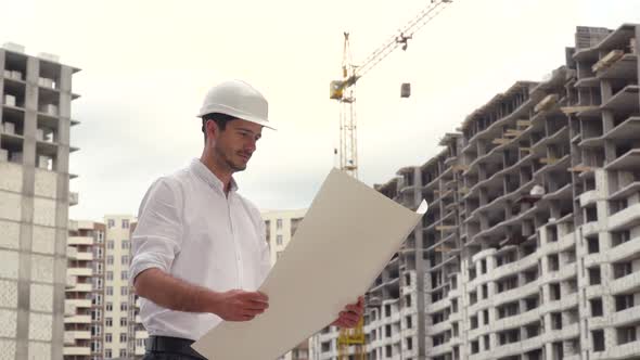 Architect or Engineer Working, Browsing Building Project of Construction Site with Blueprint Plan