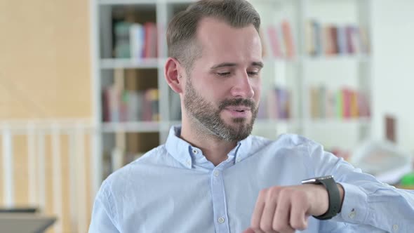 Portrait of Young Man Talking on Smart Watch