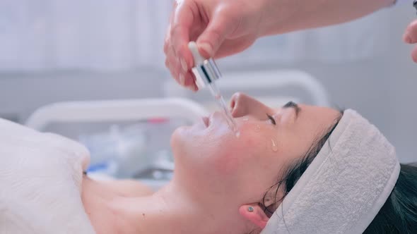 Beautician Applies Serum to to the Girls Skin