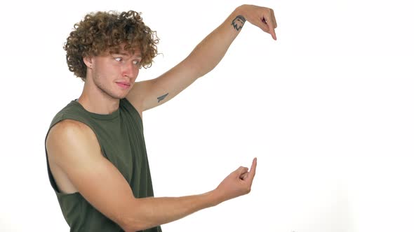 Caucasian Cheerful Guy with Curly Hair Looking on Camera Inviting with Facial Expressions to Look at
