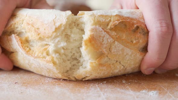 Slow Motion of Hands Breaking a Freshly Baked Loaf of Bread