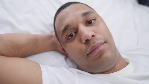 Closeup Face of Young Relaxed African American Man with Brown Eyes Looking at Camera Smiling