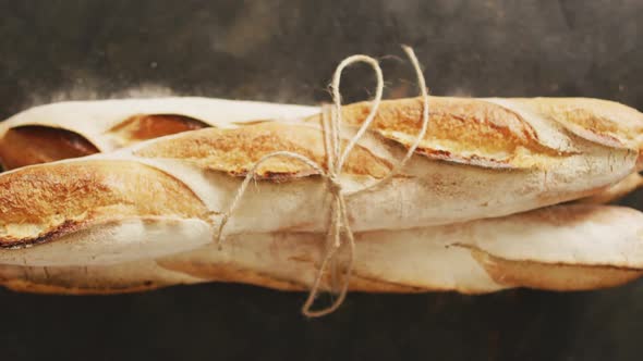 Video of baguettes tied with lace on a black surface