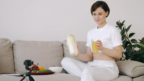 A Pretty Fit Woman with Fresh Juice Is Making a Video