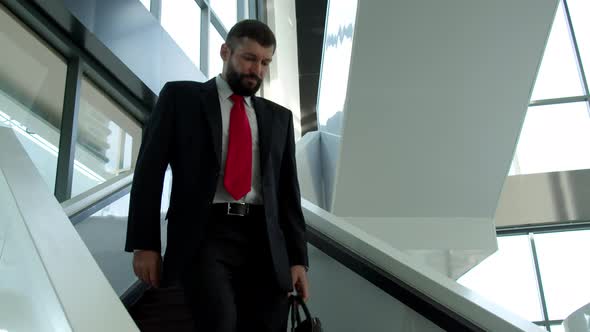 Cute Caucasian Man Chief Executive Officer Descends the Stairs in the Office of a Modern Company