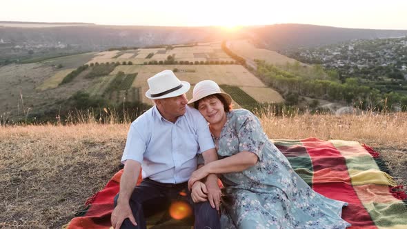 Elderly Couple at the Summer Picnic at Sunset