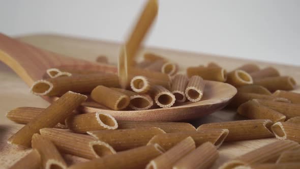 Whole raw ecological integral penne pasta falling in slow motion