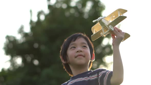 Cute Asian Child Playing Wooden Airplane In The Park Outdoors Slow Motion